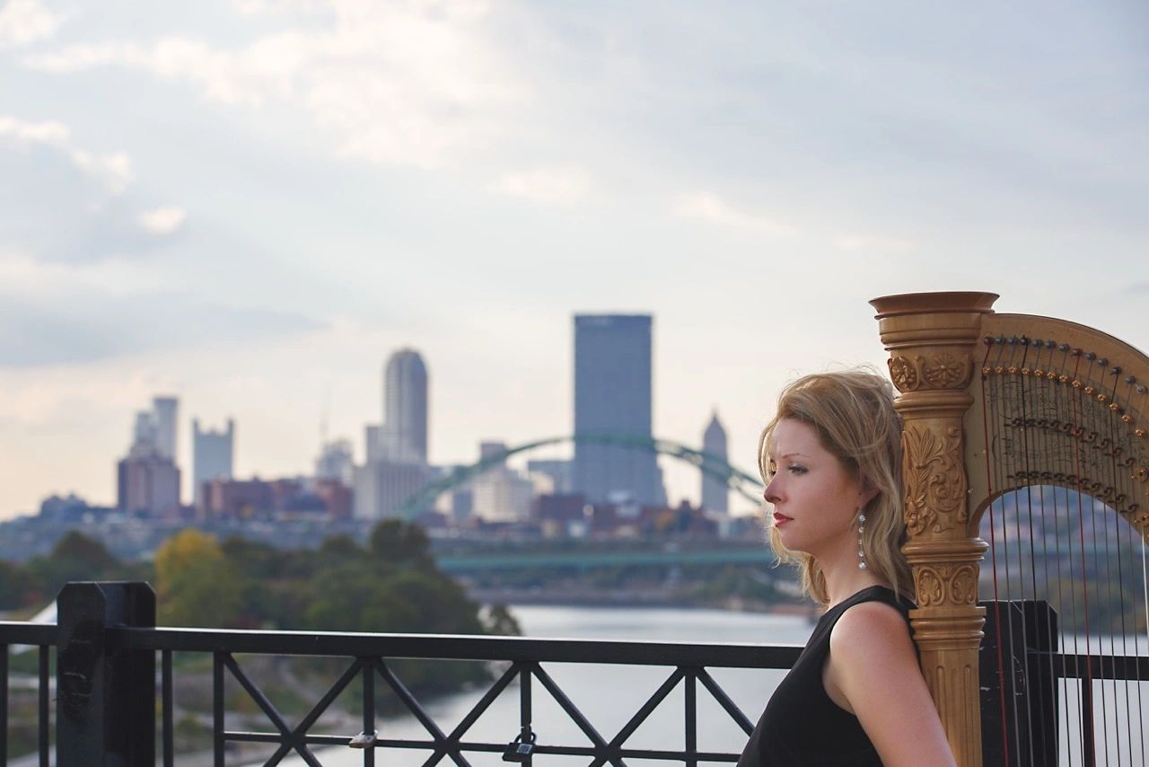 Marissa performing with Pittsburgh cityscape